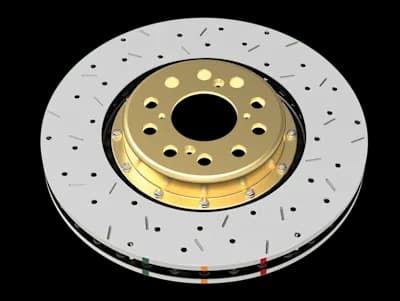 DBA 5000 Series XS brake rotor with cross-drilled holes and slots on silver surface featuring gold center hub and colored indicator markings