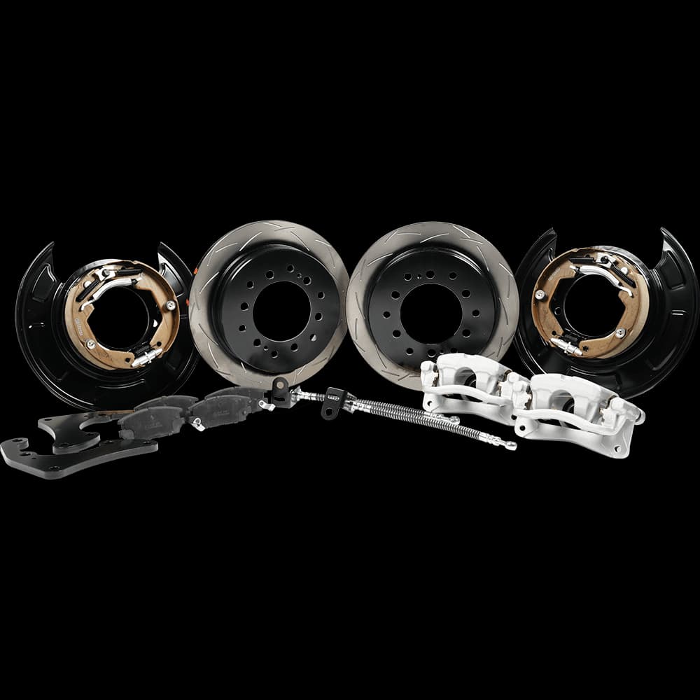 Complete drum to disc brake conversion kit showing brake rotors, calipers, brake shoes, backing plates and hardware components on white background