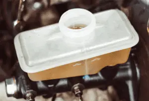 Correctly filled brake fluid reservoir showing proper fluid level at maximum mark following complete brake system bleeding Brake fluid reservoir with translucent plastic showing fluid level at proper maximum fill line after completing brake bleeding procedure