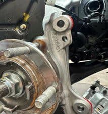 Step 4B: Identifying contact points on OE hub casting that require removal for proper DBA caliper fitment Original equipment hub casting with visible contact area marked for modification to ensure proper clearance for DBA caliper installation