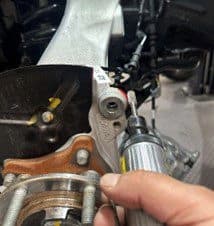 Step 4C: Marking excess casting material on OE hub that requires removal to accommodate DBA performance brake caliper Technician marking contact points on original equipment hub casting where excess material needs to be removed for DBA caliper clearance